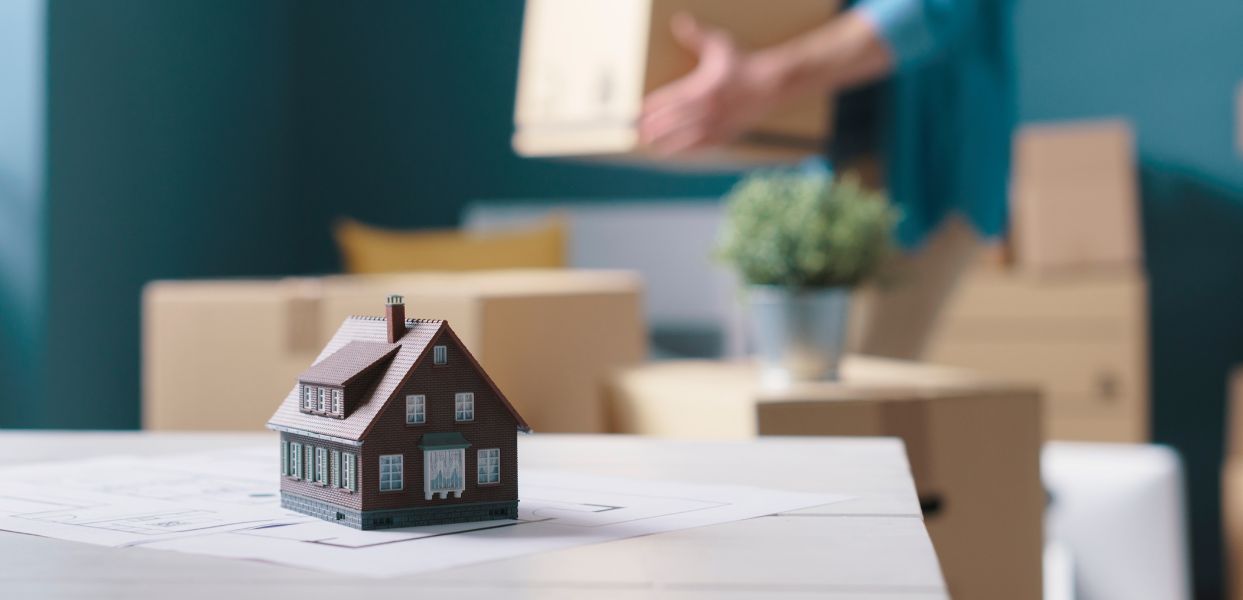 model of house and removal boxes in background