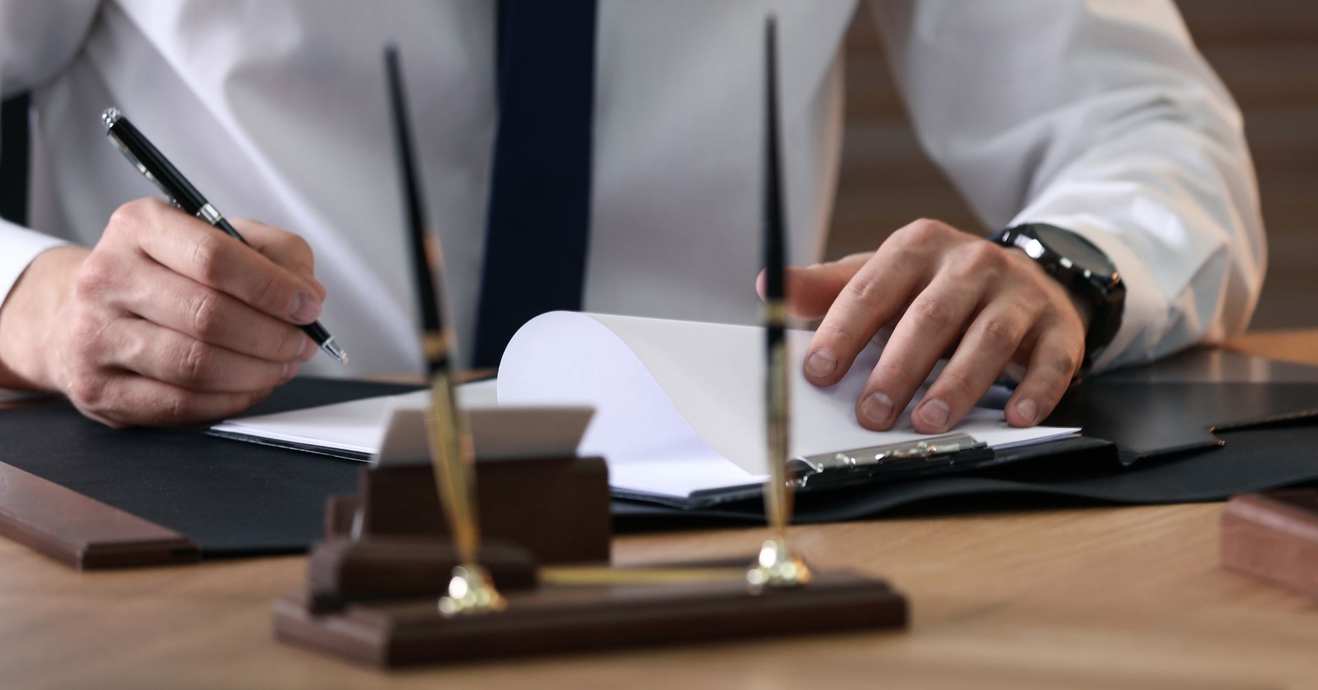 man at desk signing papers
